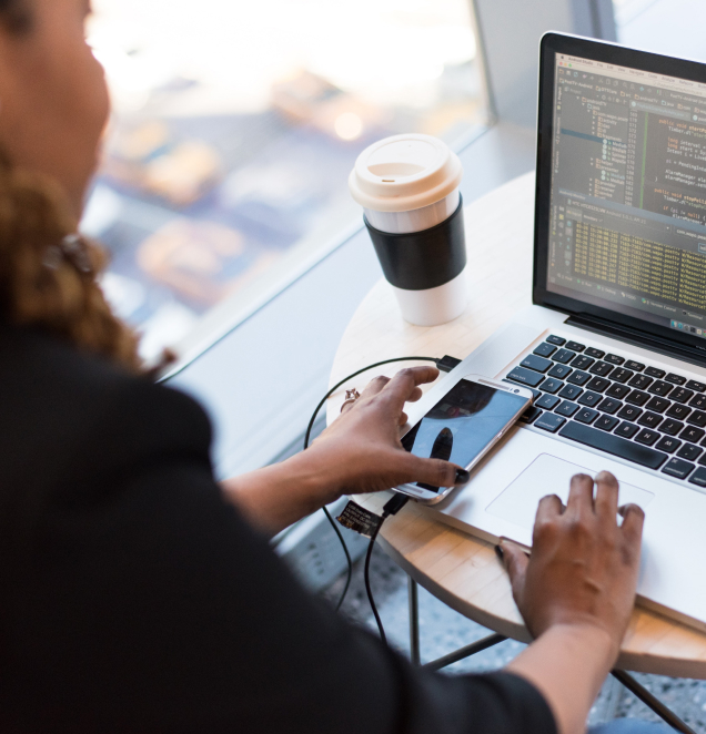 A woman focused on her laptop, typing intently as she engages with her work or studies.