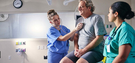 A nurse conducts a medical examination of a patient in a hospital setting, ensuring proper care and attention.