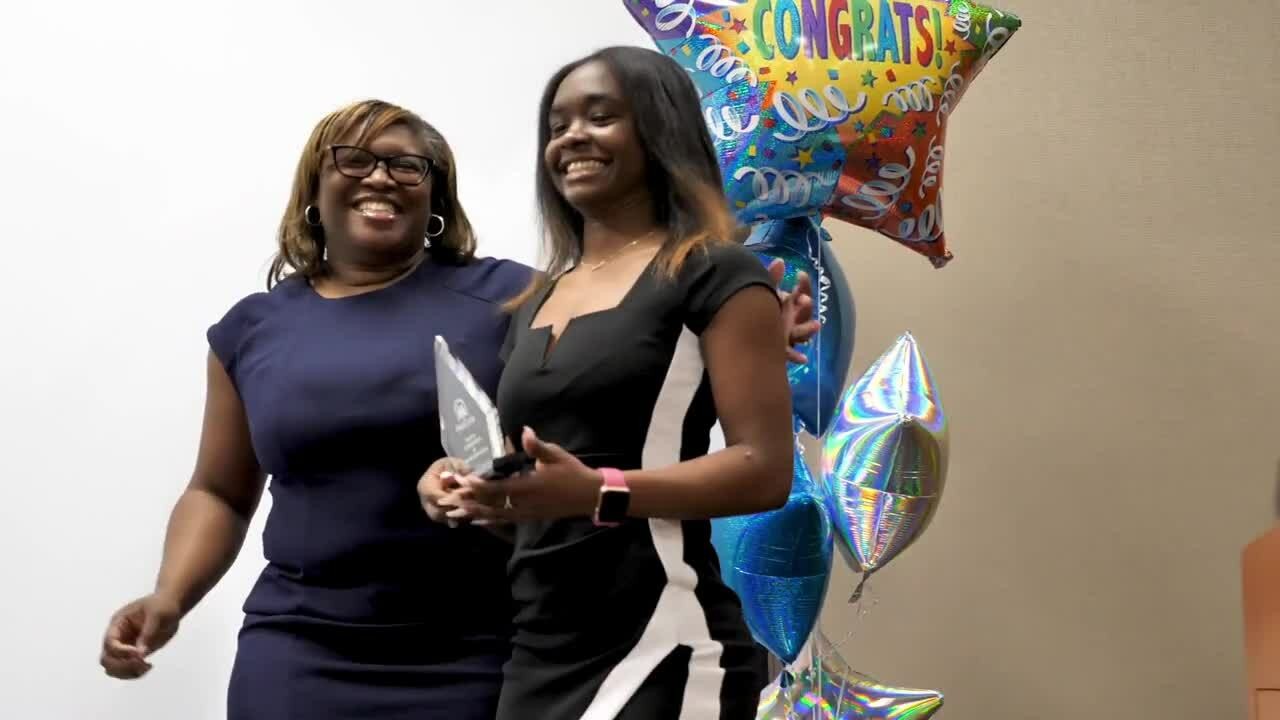 Two women stand side by side, each holding colorful balloons, smiling and enjoying a cheerful moment together.