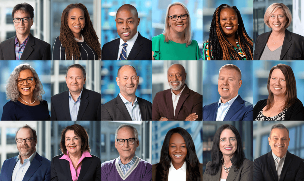 A diverse group of 15 professionals, each smiling warmly, are arranged in a 3x5 grid against an office background. They exude confidence and approachability.