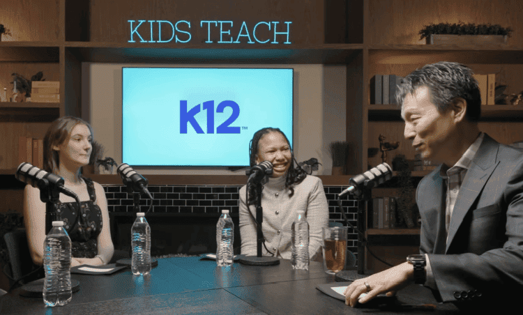 Three people sit at a podcast table with microphones, smiling and engaged in conversation. Behind them, a screen displays "K12" under "Kids Teach."